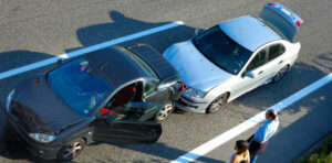 people standing on the side of the road looking at a car accident
