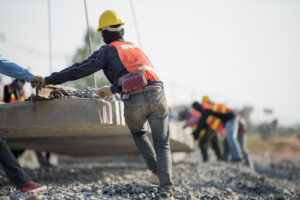 men in a construction site working while wearing orange vests